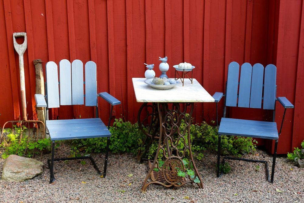 simple blue yard furniture against a red fence