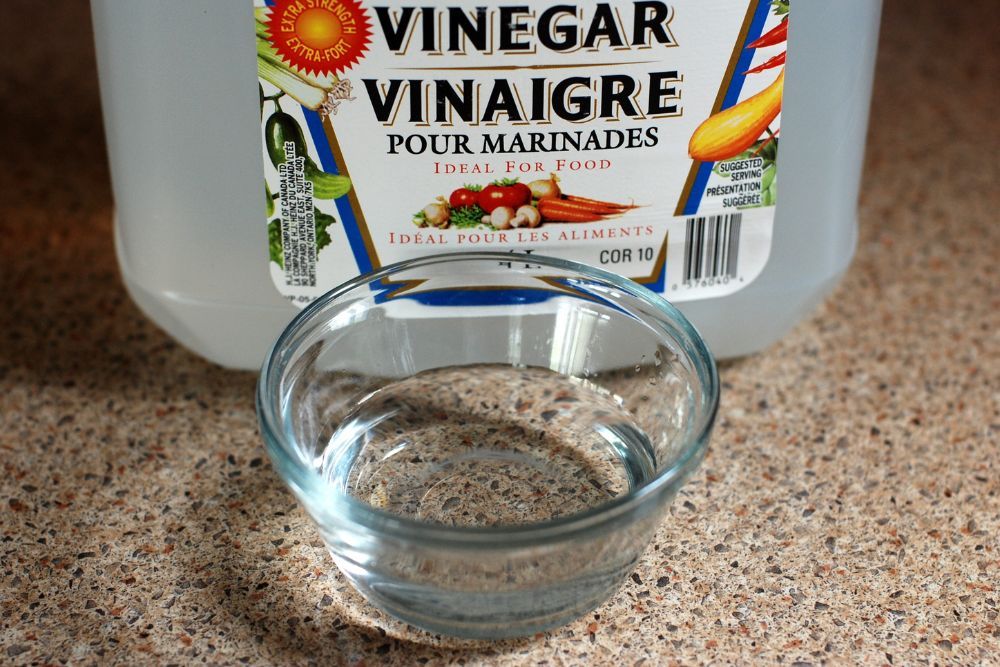 White Vinegar in a Bowl Beside a Bottle