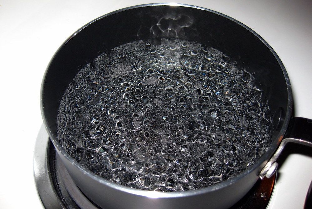 A pan of water boiling on the stove.