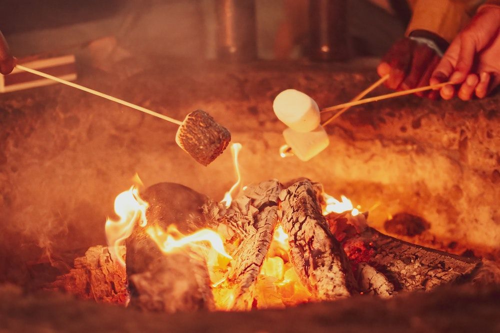 People Roasting Marshmallow over a wood burning fire pit