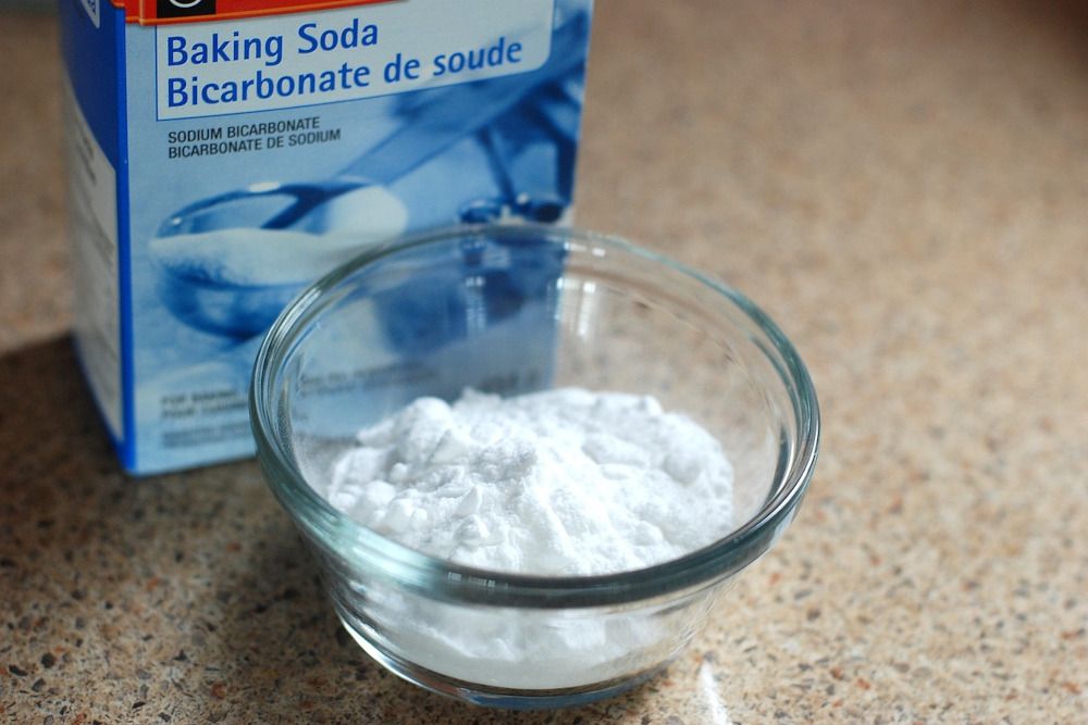 Small bowl of baking soda with box behind it.