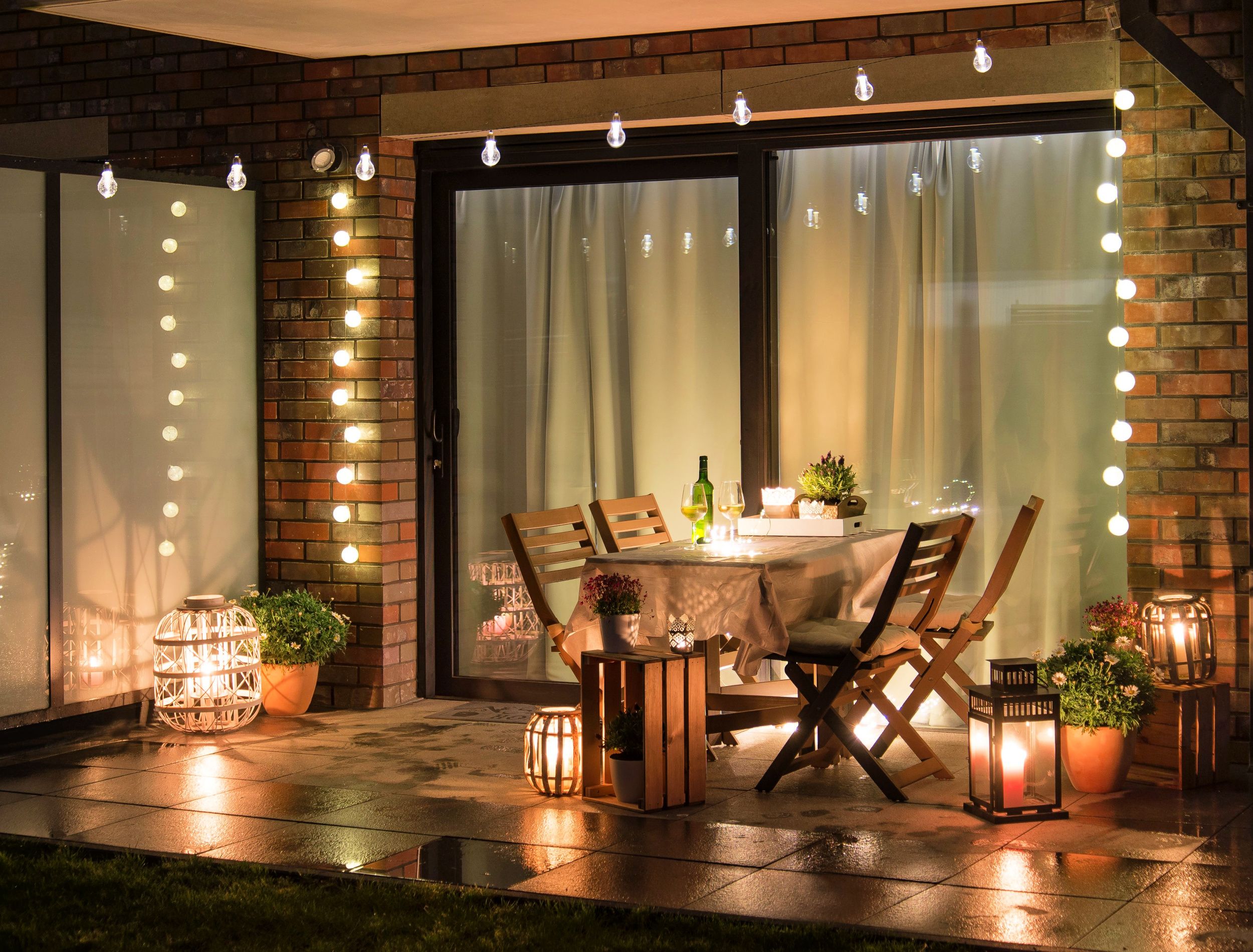 Summer evening terrace with candles, wine and lights