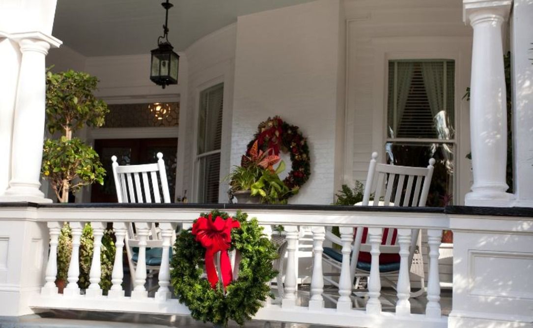 Wreaths around a sitting area on a porch
