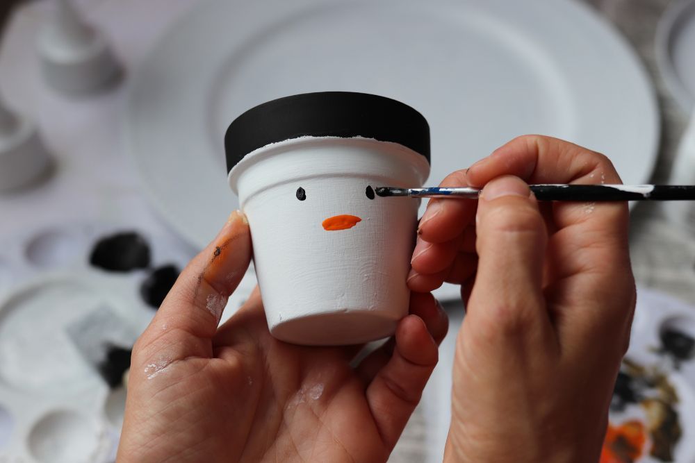 Painting a snowman on a pot
