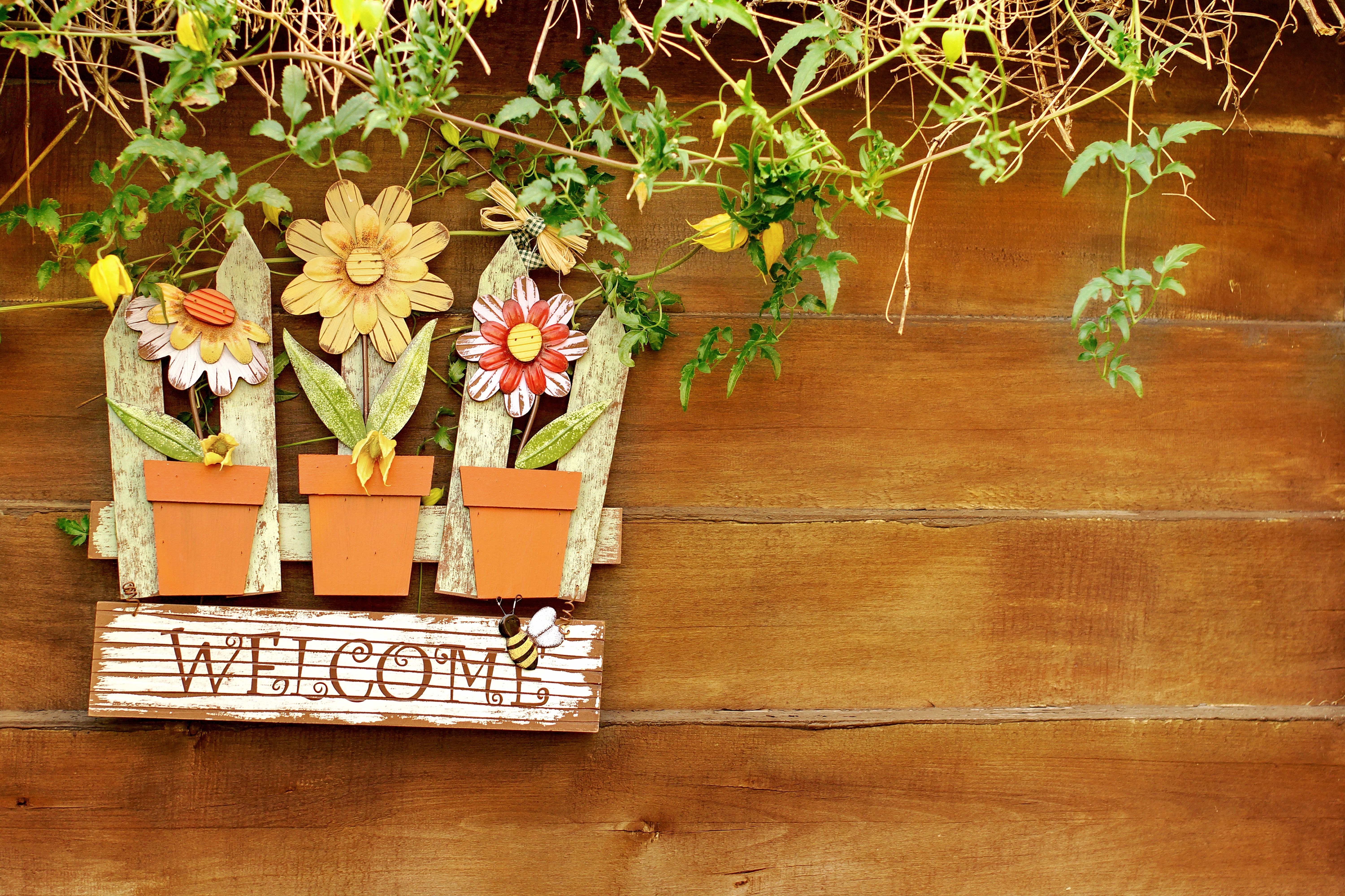 Welcome signboard on wooden fence in garden. Background with space for text or image.