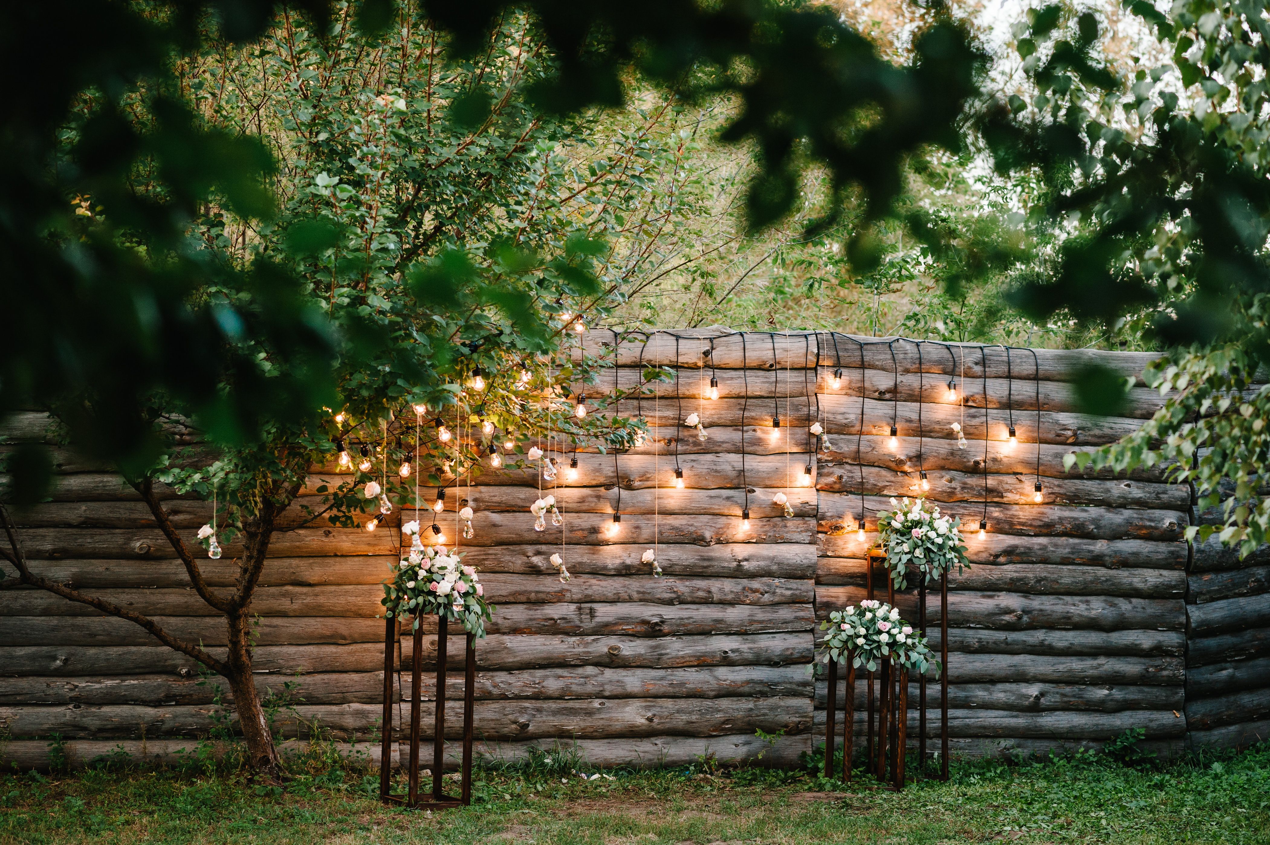 Wooden wall decorated garland with luminous bulbs and electric lamps decorated flowers.