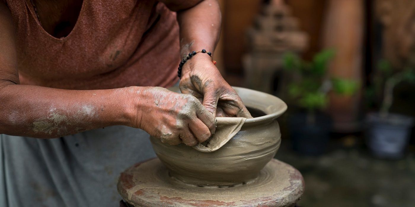 Person repairing a clay pot