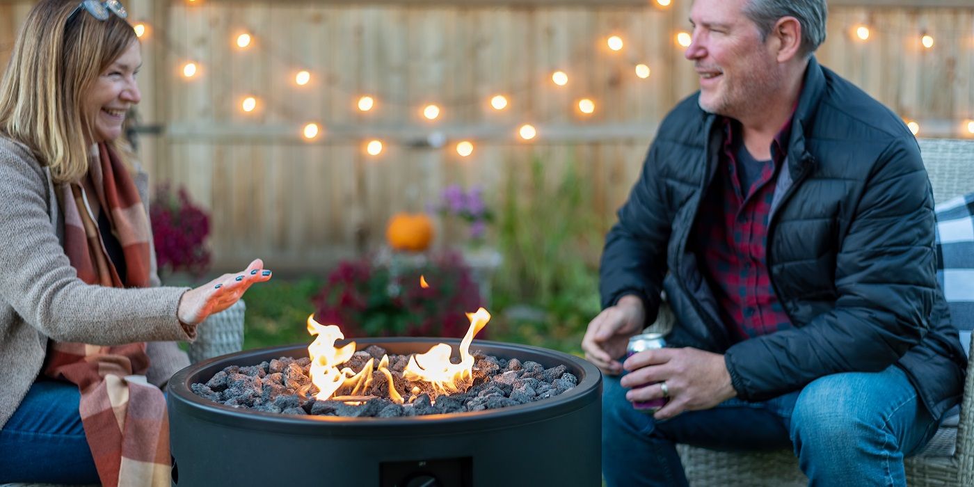 Two people outside enjoying a fire pit