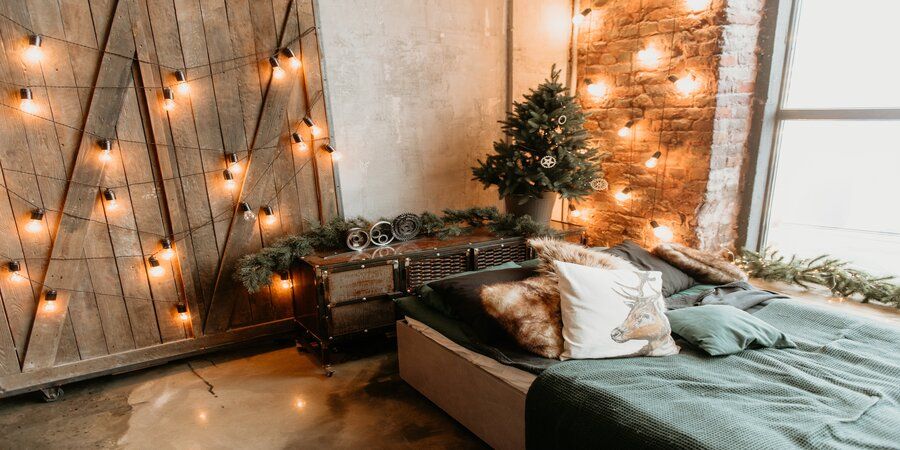 Cozy bedroom with Christmas lights on wall.