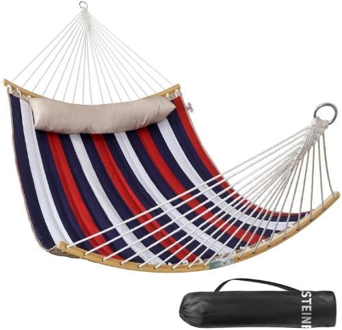 A red, white and navy blue quilted hammock with an off-white pillow and a black carry bag.