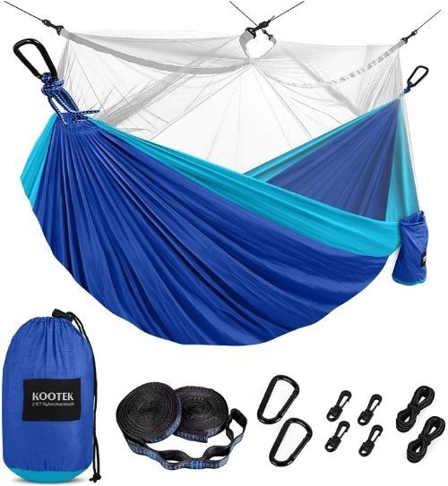 A two-tone blue parachute hammock with a bug net suspended over top. Beneath it, a blue stuff sack, 2 tree straps, carabineers and ropes are displayed.