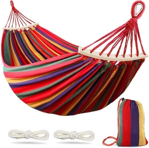A red, purple, yellow and green striped cotton hammock with curved wooden bars, a striped stuffed sake and 2 white ropes.