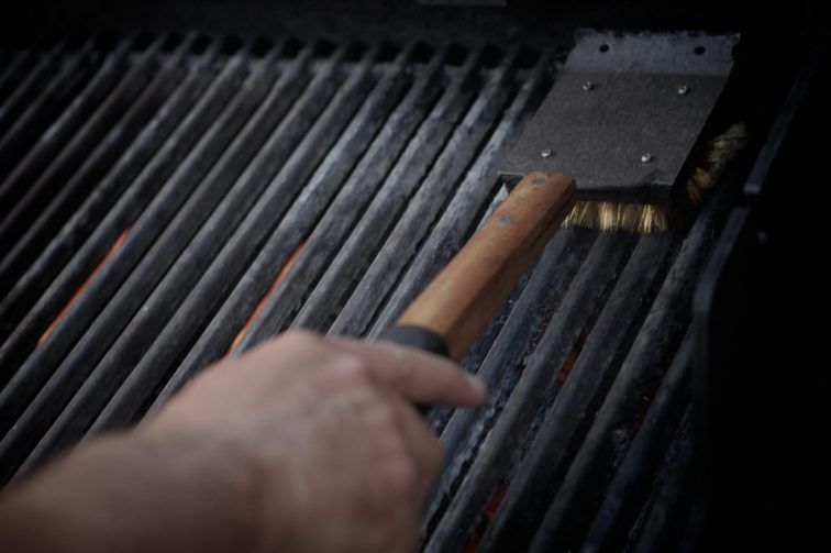 A person cleaning the grill