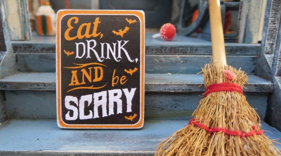 Halloween sign and straw broom on porch