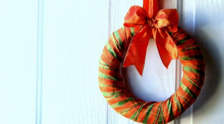 ribbon wrapped wreath on blank white door