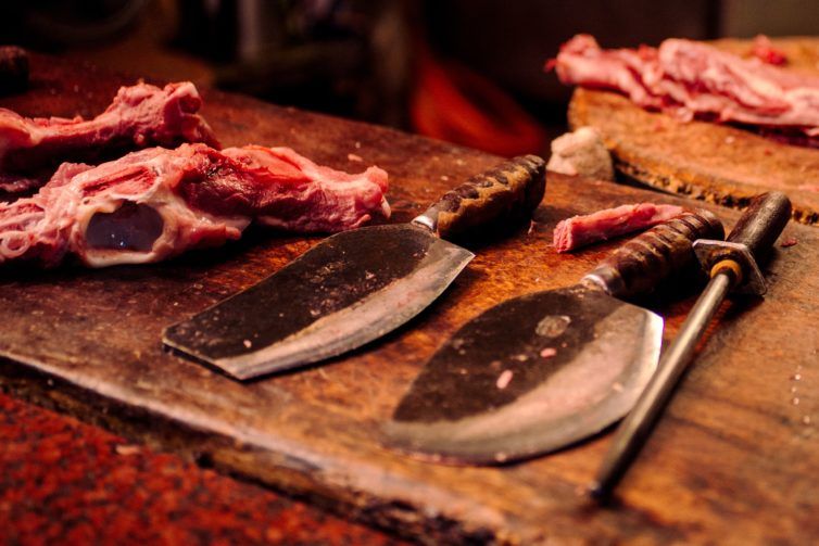 Meat and knifes on the wooden board