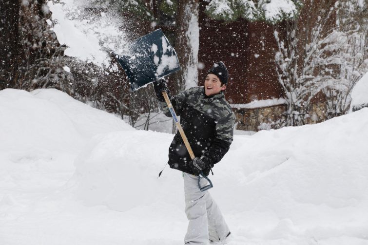 A boy shoveling the snow