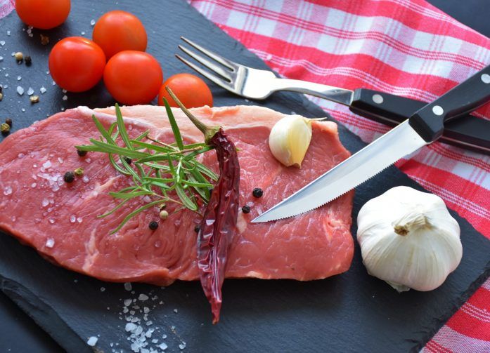 Raw Steak with garlic tomatoes rosemary and chilli